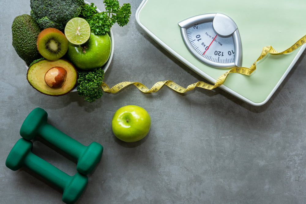 Scale, weights and healthy food to promote weight loss with CBD. 